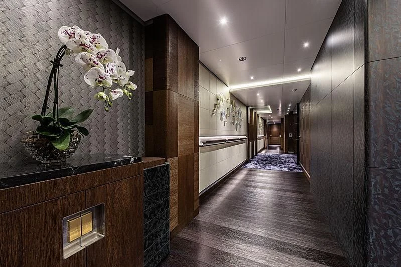 a room with a wood floor and a wood cabinet with white flowers on it aboard WHITE RABBIT Yacht for Sale
