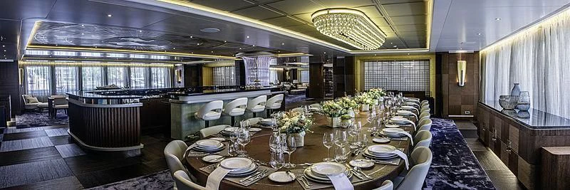 a large room with tables and chairs aboard WHITE RABBIT Yacht for Sale