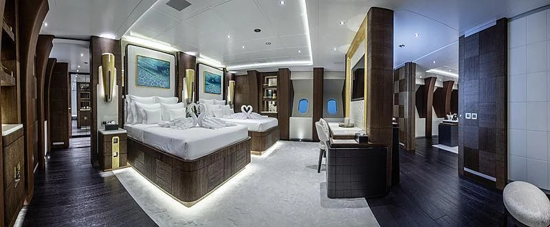 a large room with a bed and a desk aboard WHITE RABBIT Yacht for Sale