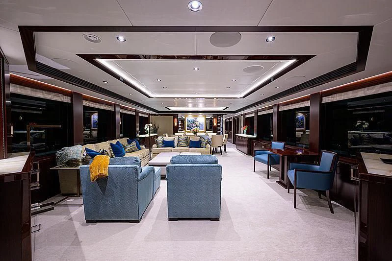 a room with a blue couch and a large mirror aboard FLAMINGO DAZE Yacht for Sale