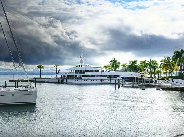 a large white boat sits in the water aboard HOME Yacht for Charter