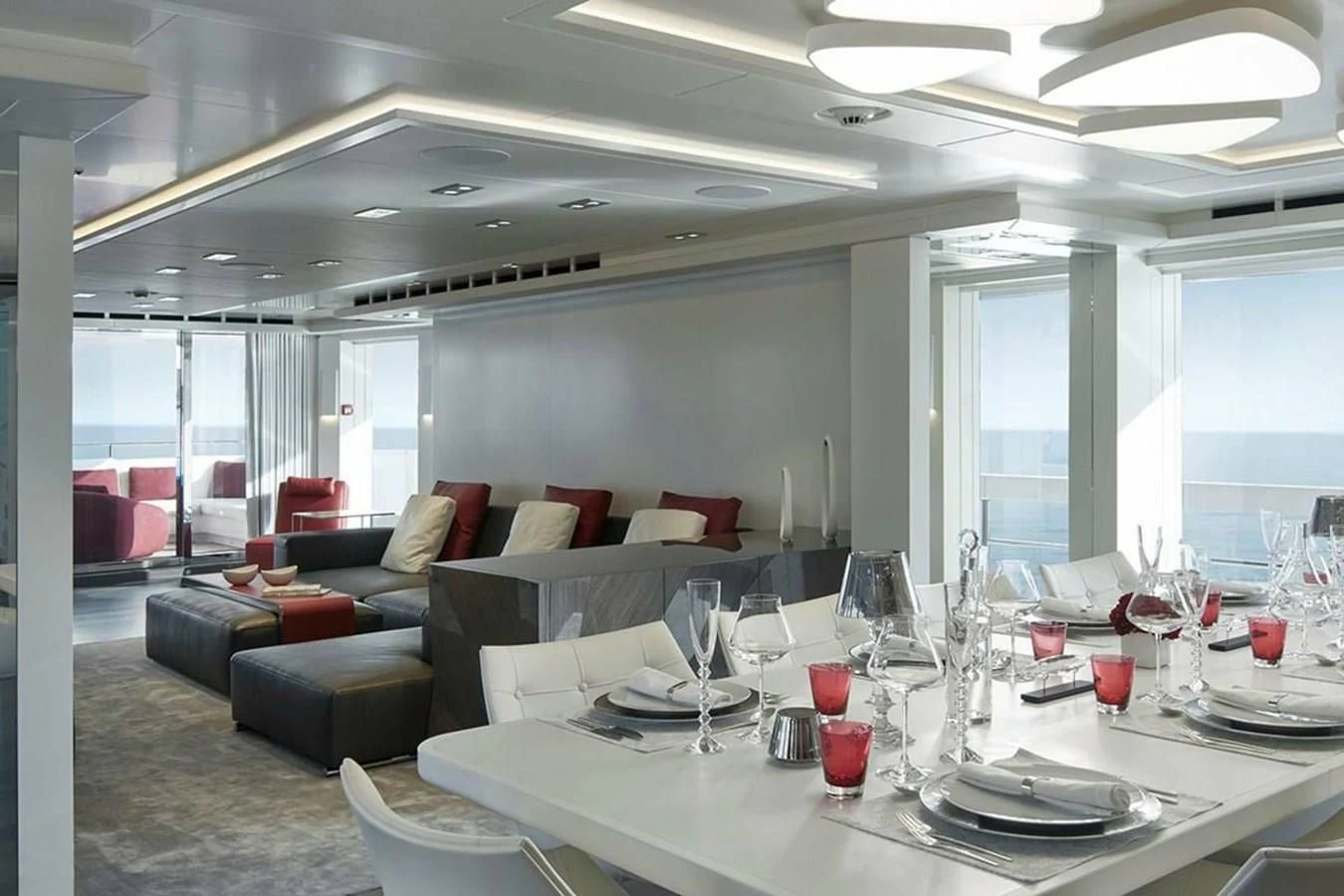 a large white table with glasses on it aboard HOME Yacht for Charter