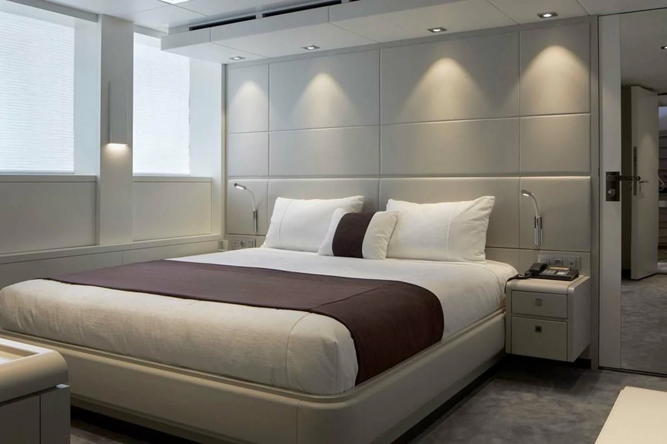 a bed with white sheets aboard HOME Yacht for Charter