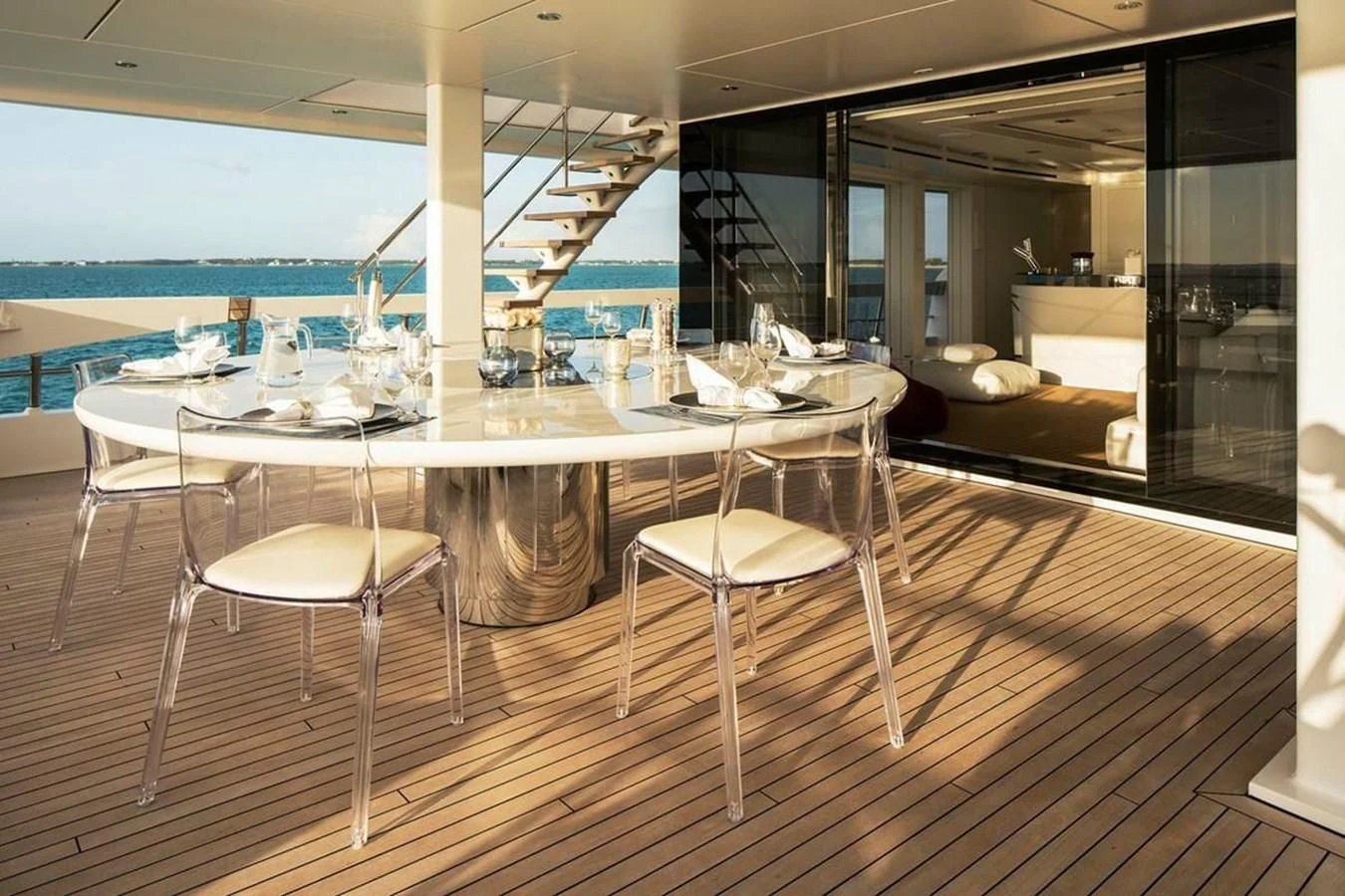 a table with chairs and a view of the ocean aboard HOME Yacht for Charter