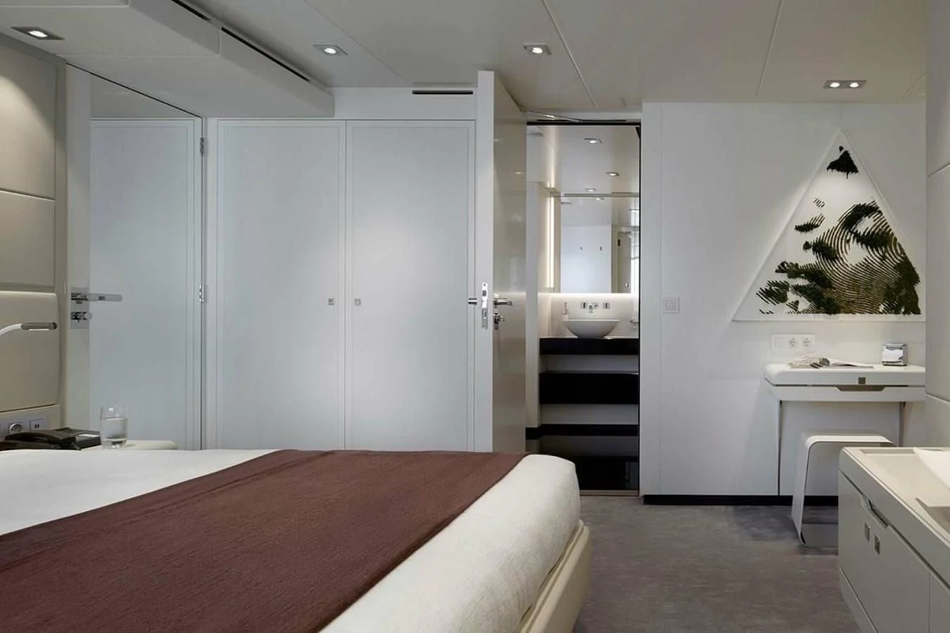 a room with a bed and a desk aboard HOME Yacht for Charter