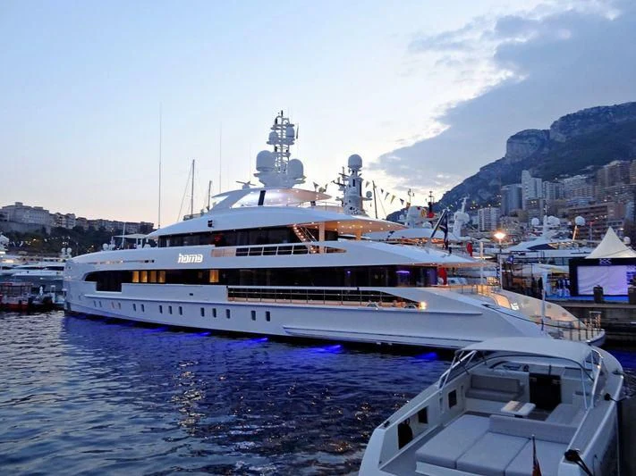 a large white boat in a harbor aboard HOME Yacht for Charter