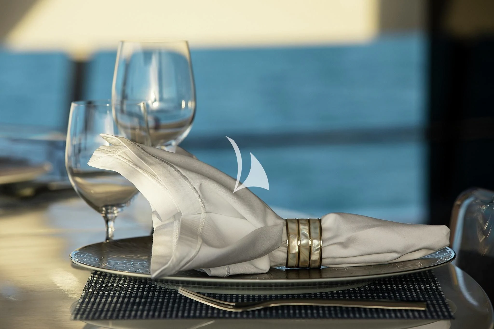 a napkin and glasses on a plate aboard HOME Yacht for Charter
