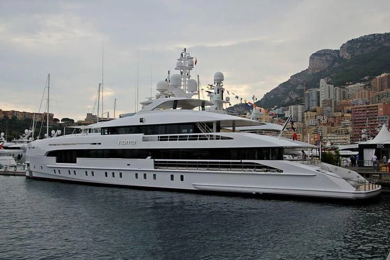 a white yacht in a harbor aboard HOME Yacht for Charter