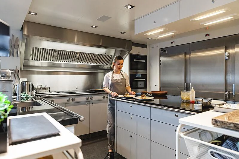 a person in a kitchen aboard HOME Yacht for Charter