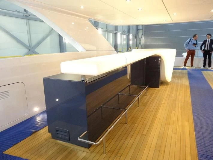 a group of people standing in a room with a large table and chairs aboard HOME Yacht for Charter