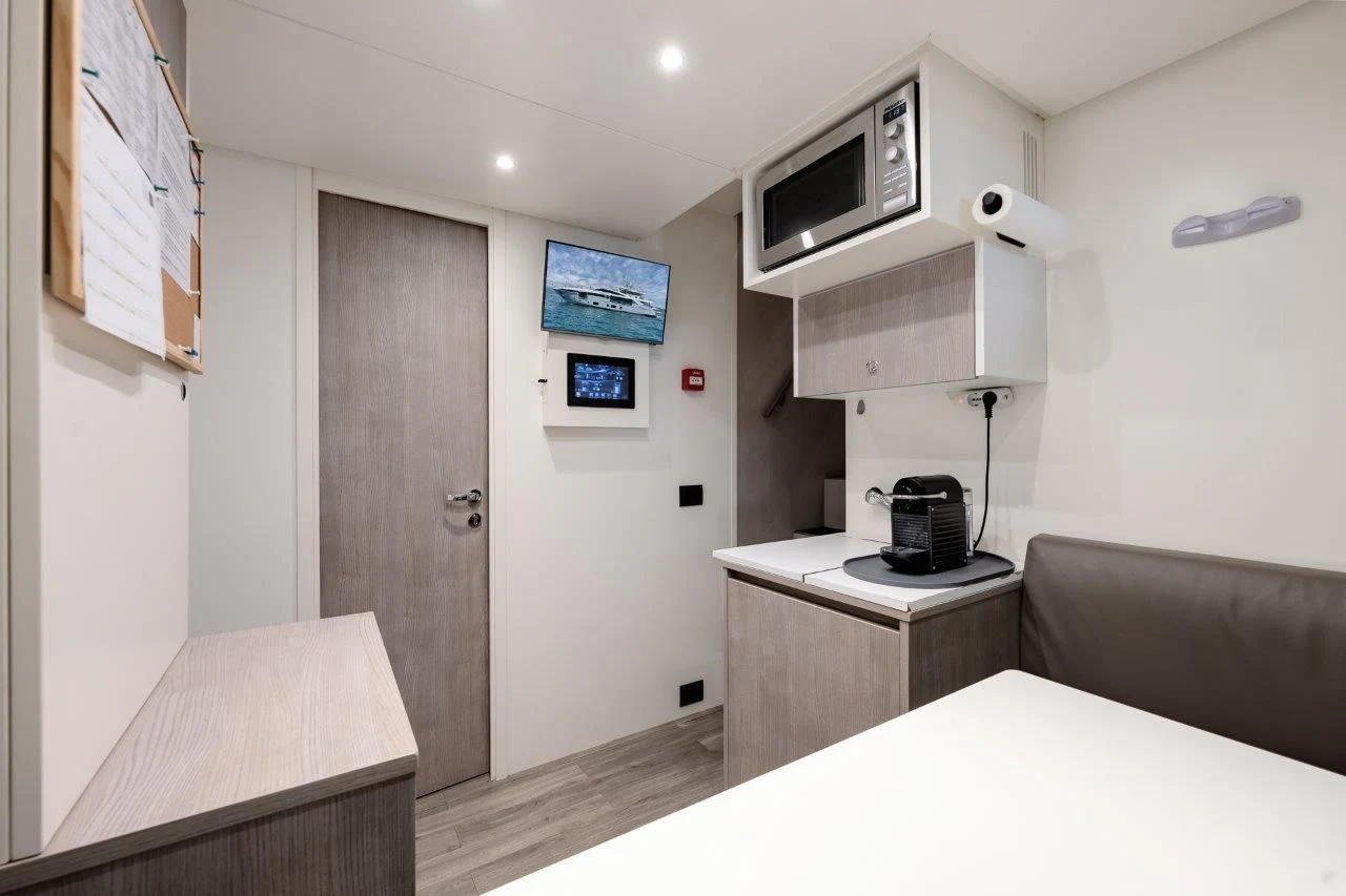 a room with a table and a tv on the wall aboard ECLIPSE Yacht for Sale