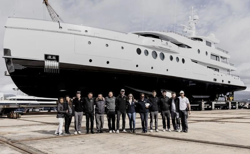 a group of people standing in front of a large plane aboard MADAME KATE Yacht for Sale