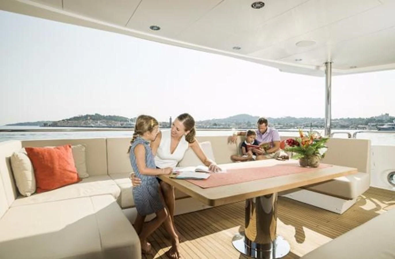 a group of people sitting around a table aboard ZOZO Yacht for Sale