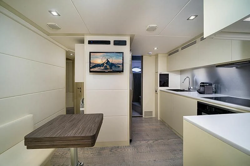 a kitchen with a table and a tv on the wall aboard UPTOWN GIRL Yacht for Sale