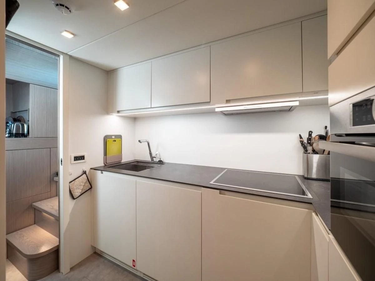 a kitchen with white cabinets aboard SURVIVOR OF LONDON Yacht for Sale
