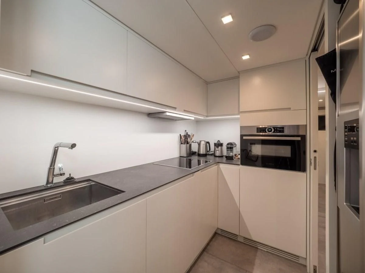 a kitchen with white cabinets aboard SURVIVOR OF LONDON Yacht for Sale