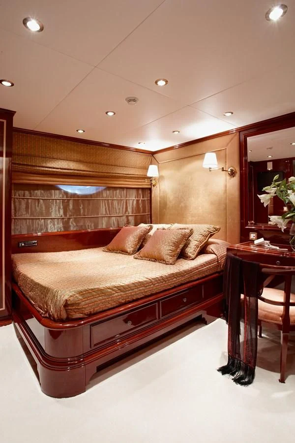 a bed with a wooden headboard aboard IRAKLIS L Yacht for Charter
