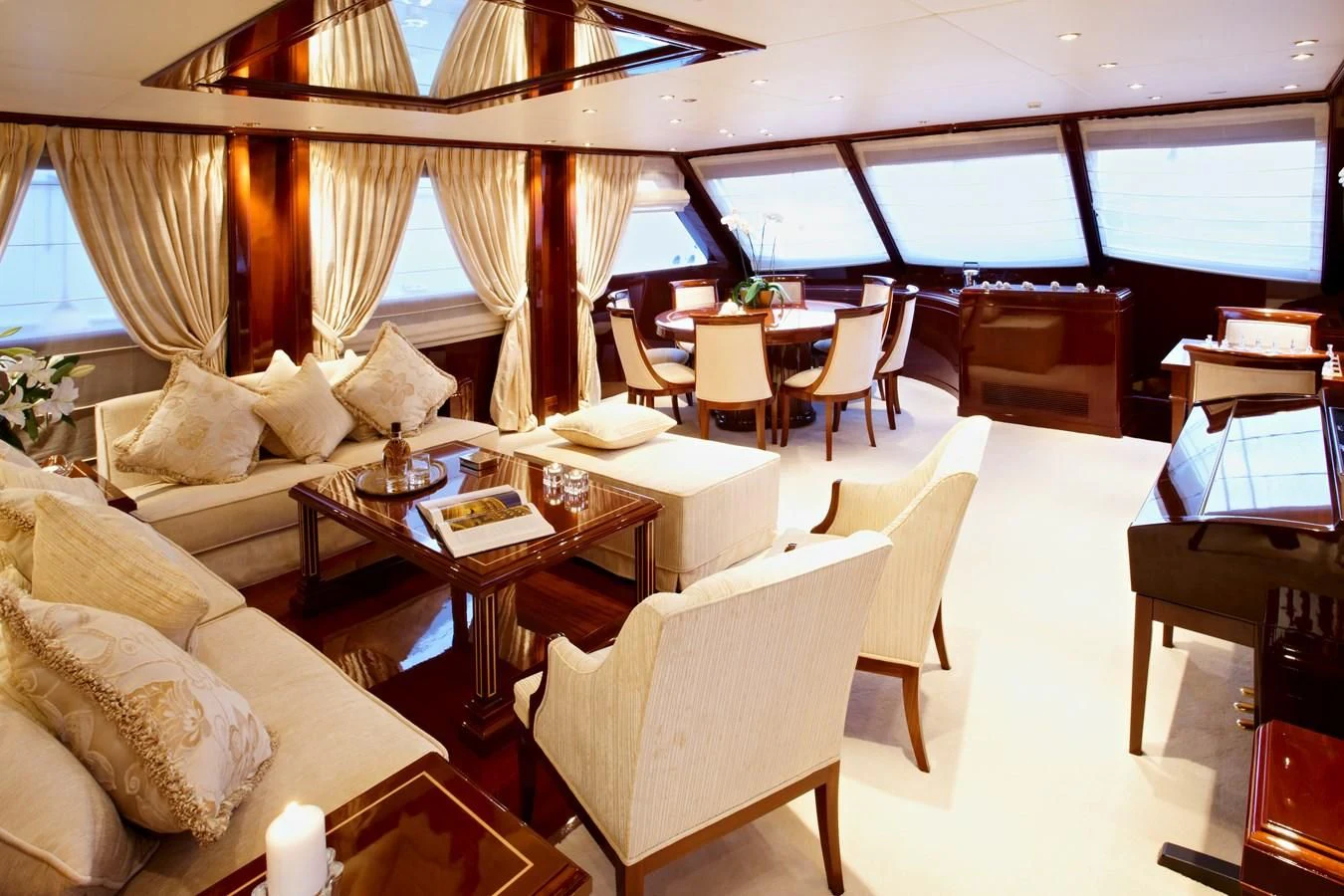 a room with a couch and a table with chairs and a large window aboard IRAKLIS L Yacht for Charter