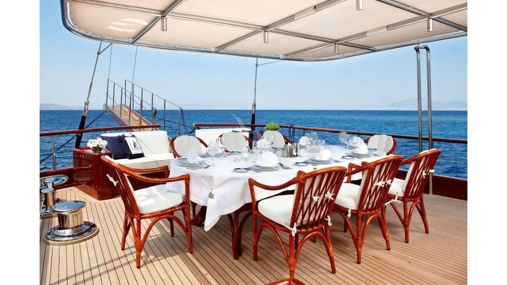 a table set for a meal on a deck overlooking the ocean aboard IRAKLIS L Yacht for Charter