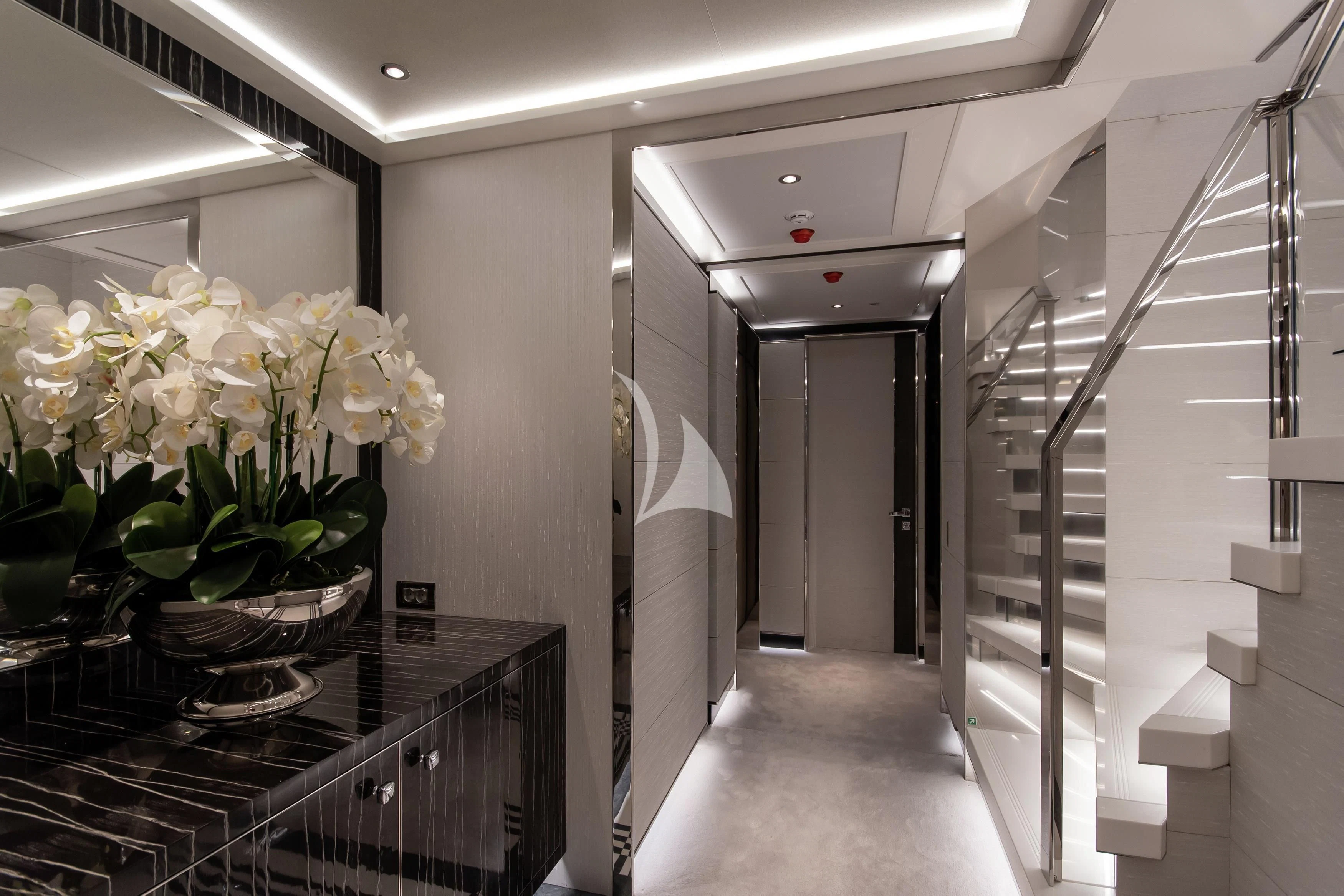 a hallway with a table and vases of flowers aboard NORTH STAR Yacht for Sale