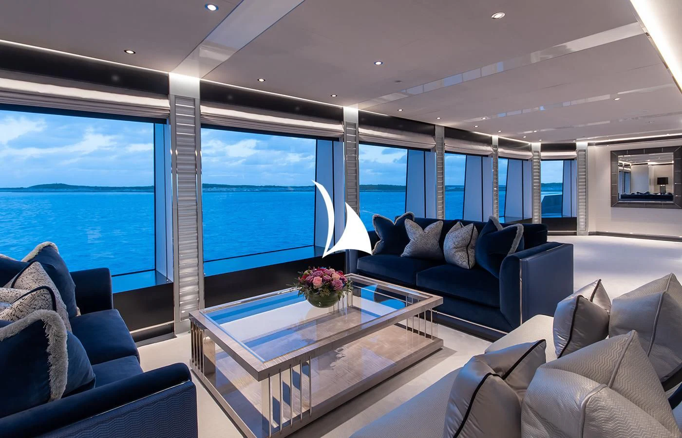 a living room with a large glass table and a view of the ocean aboard NORTH STAR Yacht for Sale