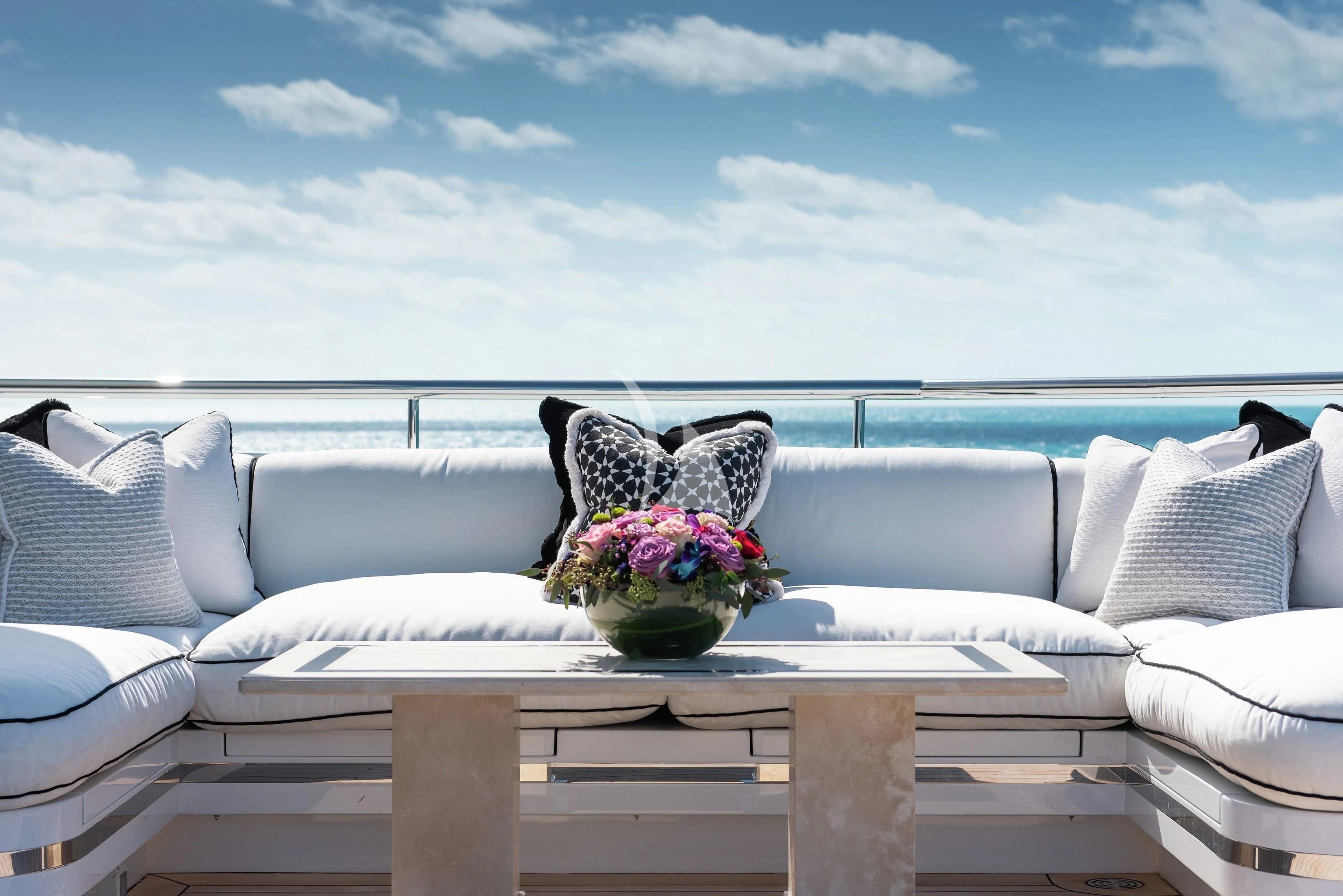 a white couch with a vase of flowers on it aboard NORTH STAR Yacht for Sale