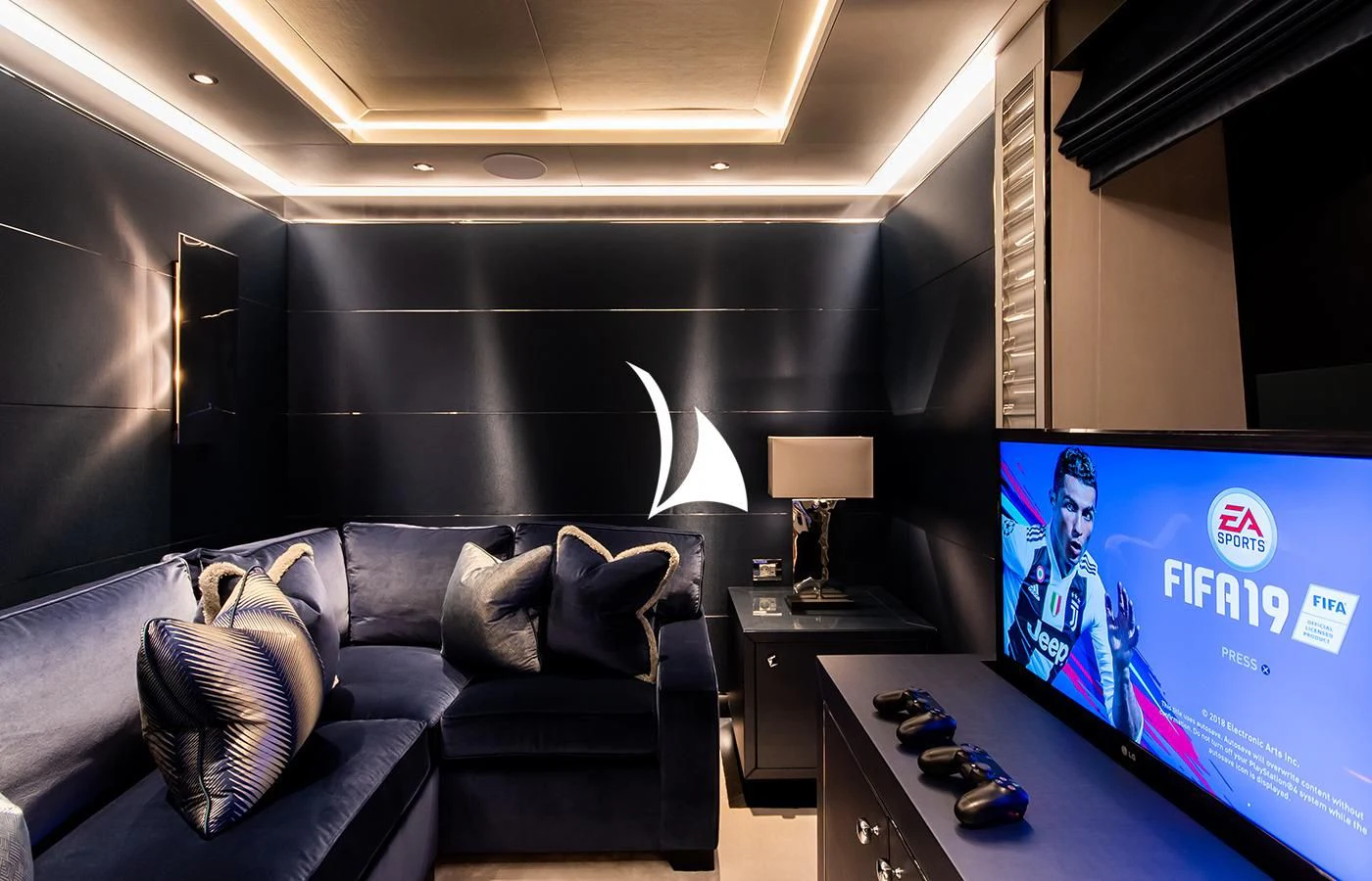 a living room with a blue couch and a television aboard NORTH STAR Yacht for Sale