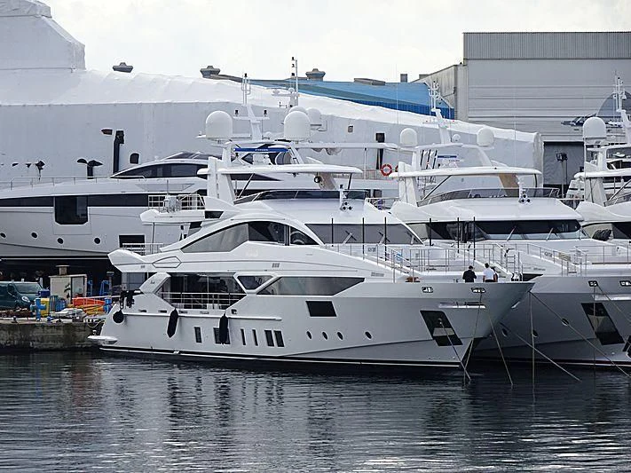 a white yacht in a harbor aboard IRONMAN Yacht for Sale
