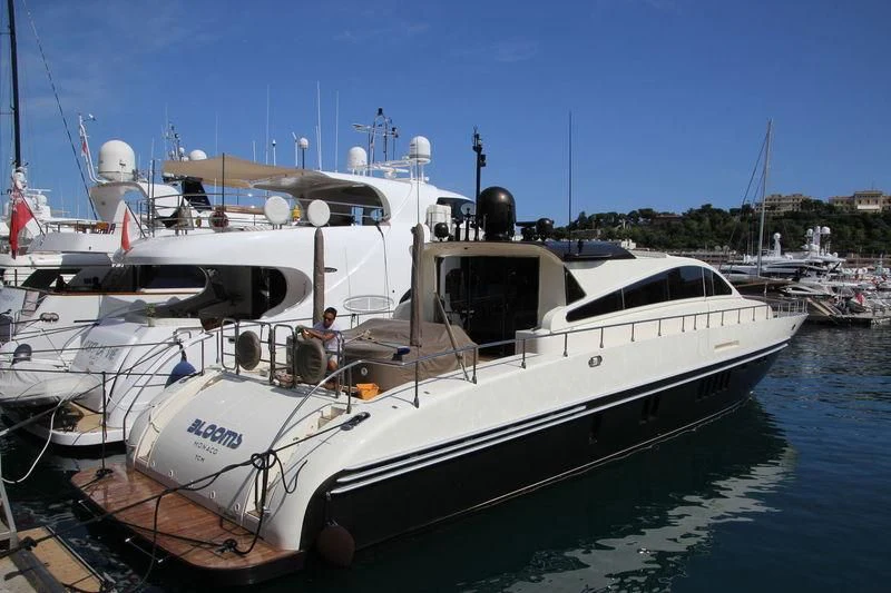 a white boat with a propeller with HMS M33 in the background aboard BLOOMS Yacht for Sale