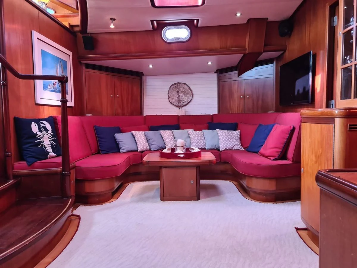 a living room with a red couch aboard WHIRLWIND Yacht for Sale