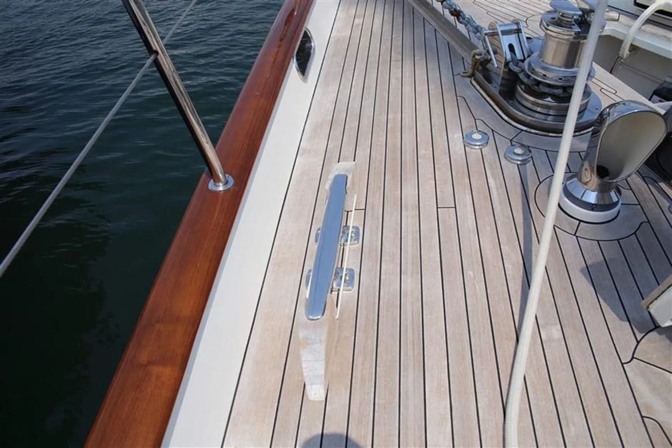 a wooden deck with a railing and a boat on it aboard WHIRLWIND Yacht for Sale