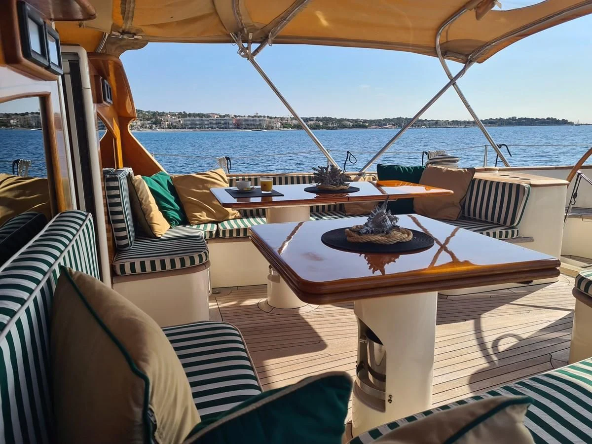 a boat with a table and chairs aboard WHIRLWIND Yacht for Sale