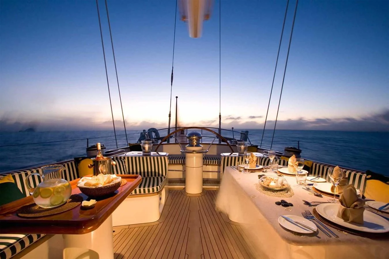 a table with food on it on a deck overlooking a large body of water aboard WHIRLWIND Yacht for Sale