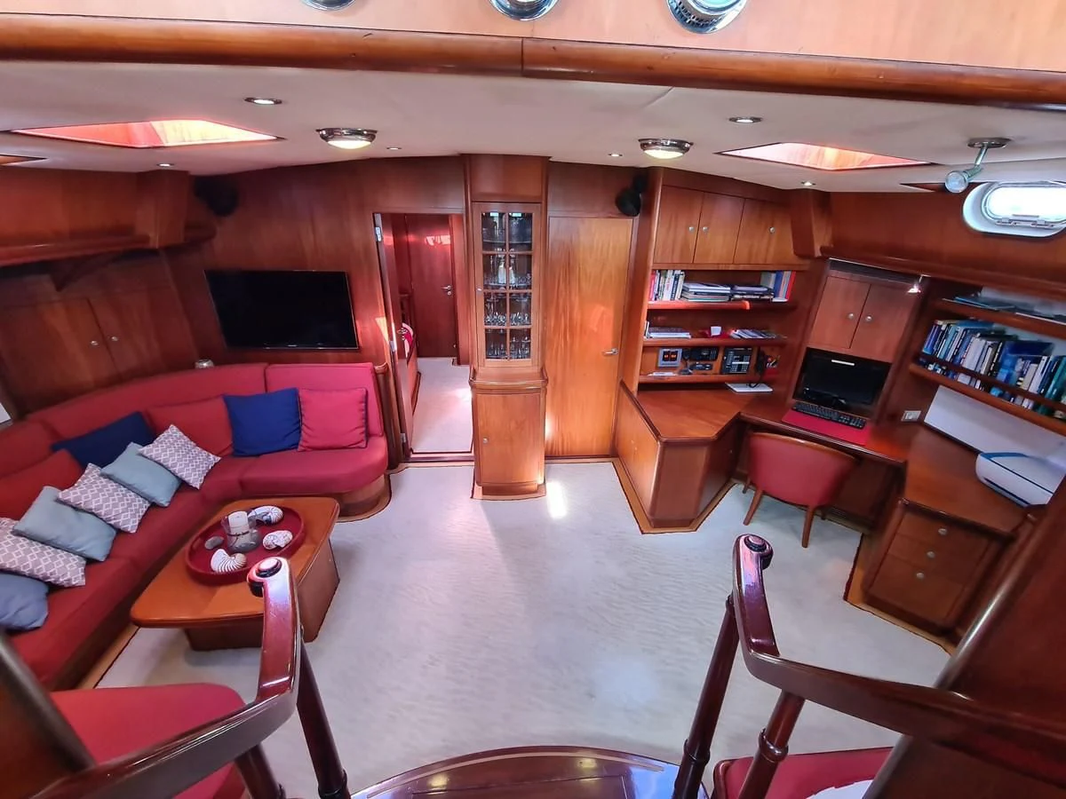 a living room with a couch and a book shelf aboard WHIRLWIND Yacht for Sale