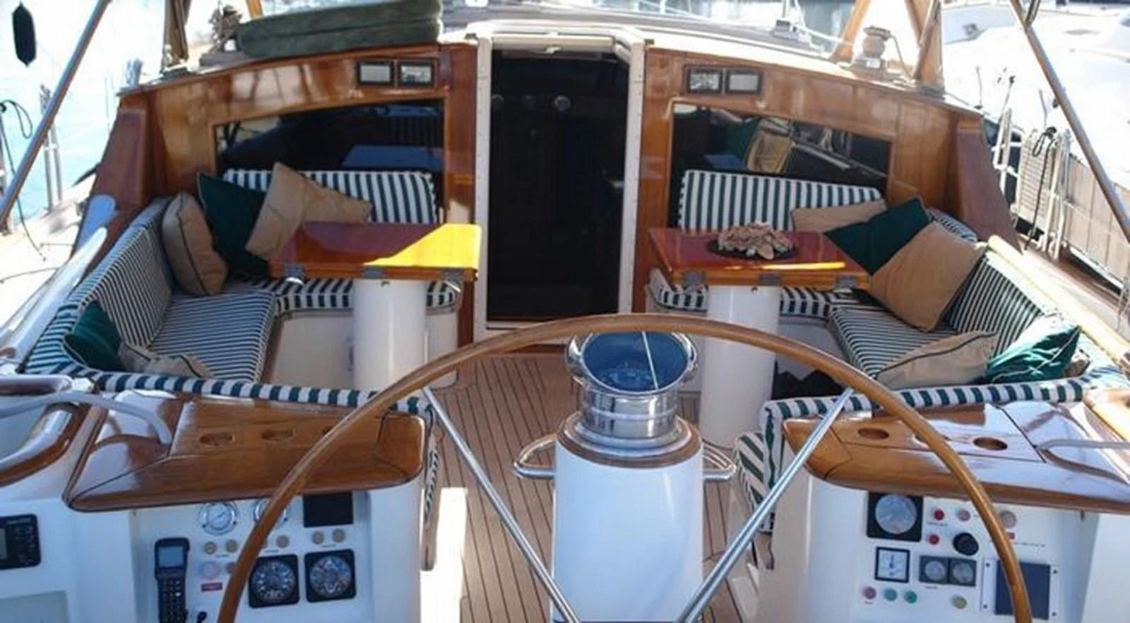 a wooden table with a glass container and a stack of books on it aboard WHIRLWIND Yacht for Sale