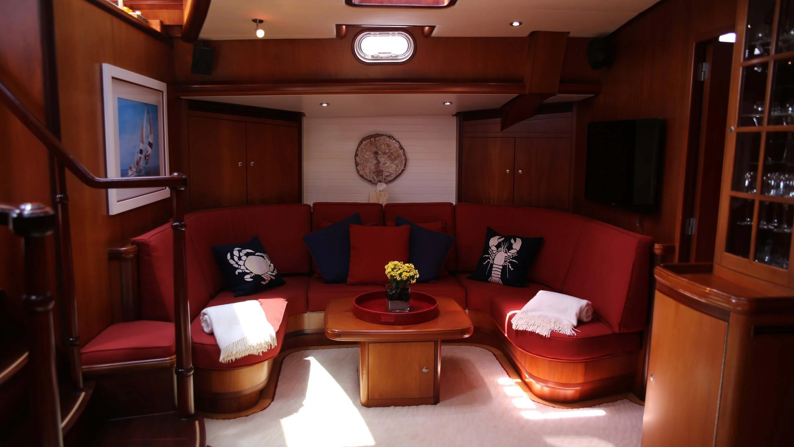 a living room with a red couch aboard WHIRLWIND Yacht for Sale