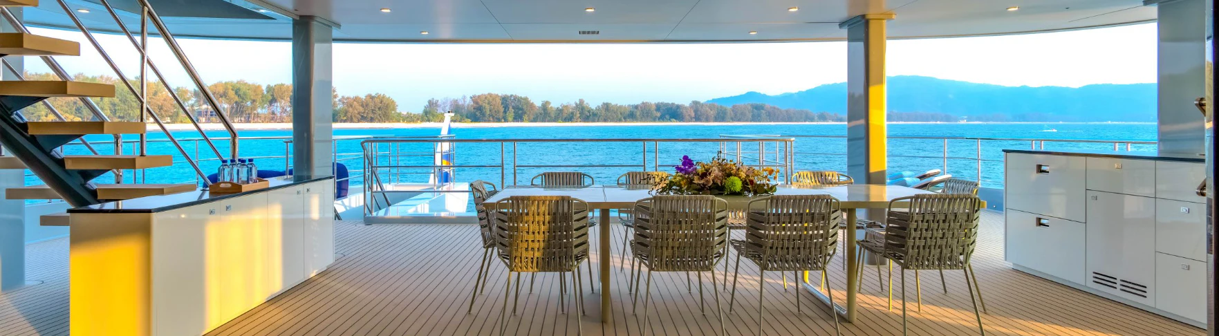 a large room with a table and chairs and a view of the ocean aboard SILVERCAT Yacht for Sale