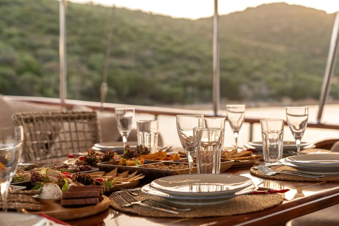 a table with food and wine glasses aboard L'ORIENT Yacht for Sale