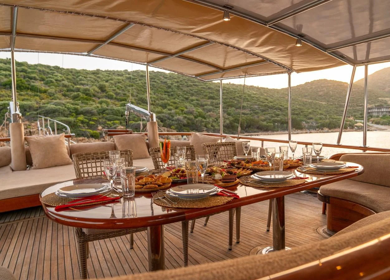a table set with plates and glasses aboard L'ORIENT Yacht for Sale