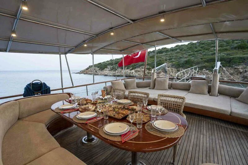 a table set for a meal on a deck aboard L'ORIENT Yacht for Sale