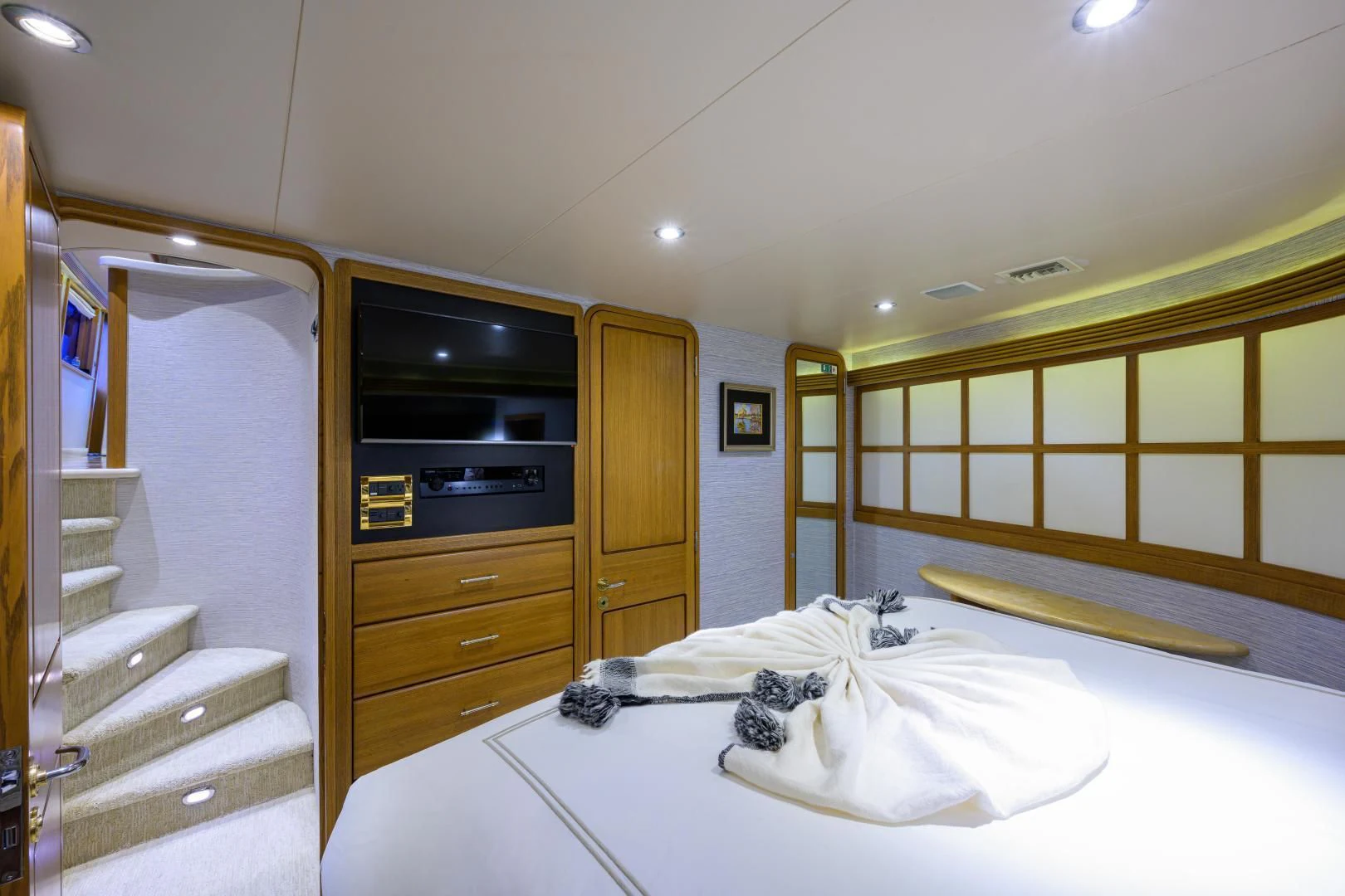 a bedroom with a bed and a television aboard SUPERSTAR Yacht for Charter
