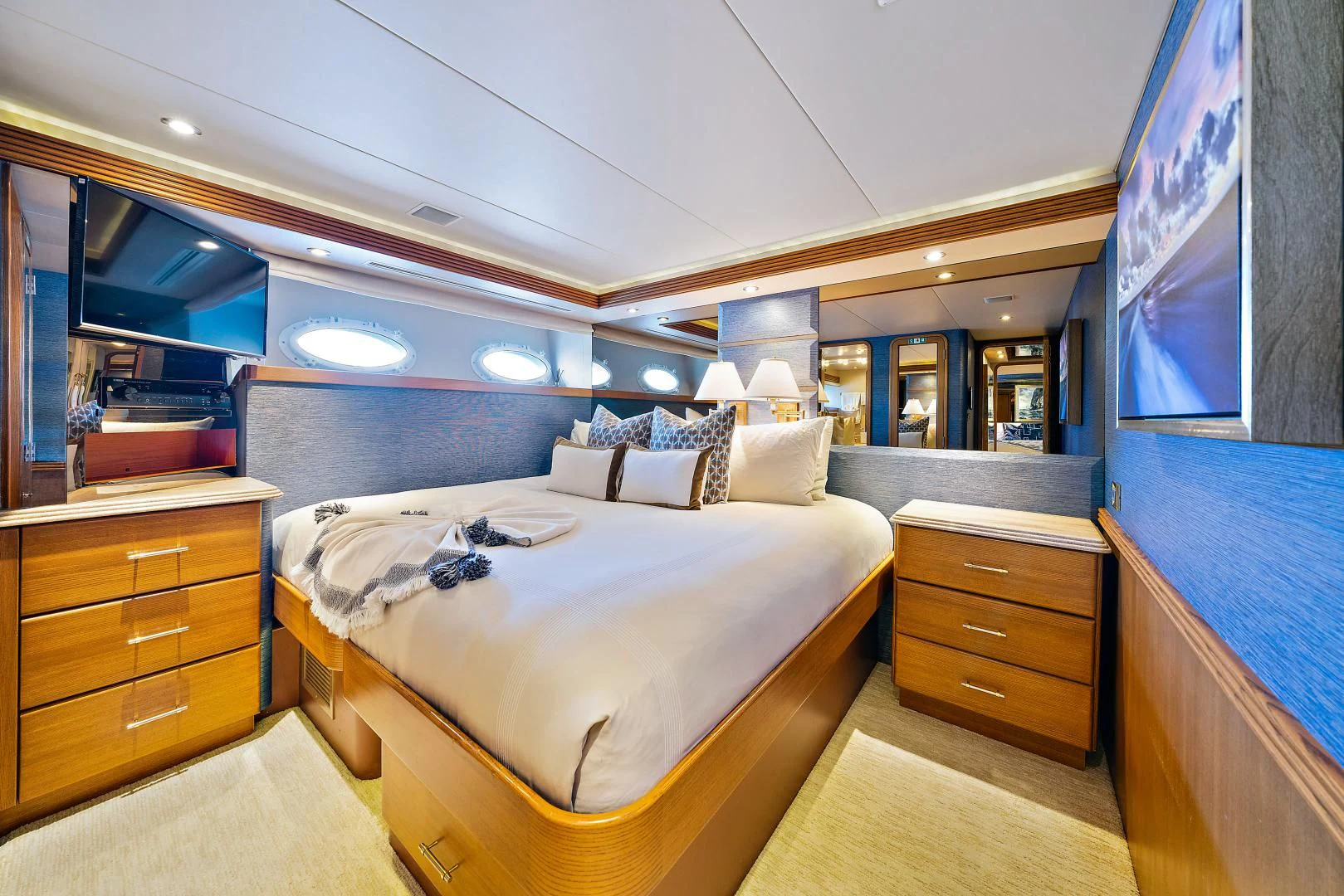a bedroom with a bed and a dresser aboard SUPERSTAR Yacht for Charter