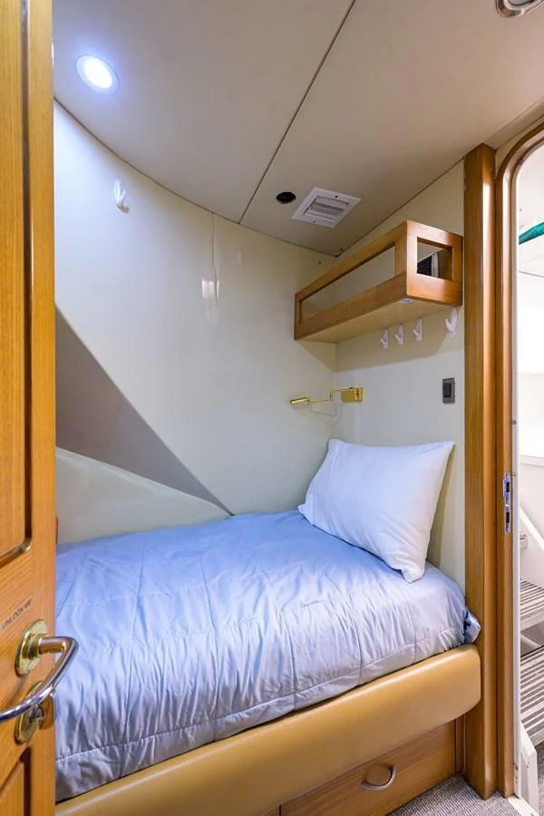a bedroom with a bed and a shelf aboard SUPERSTAR Yacht for Charter