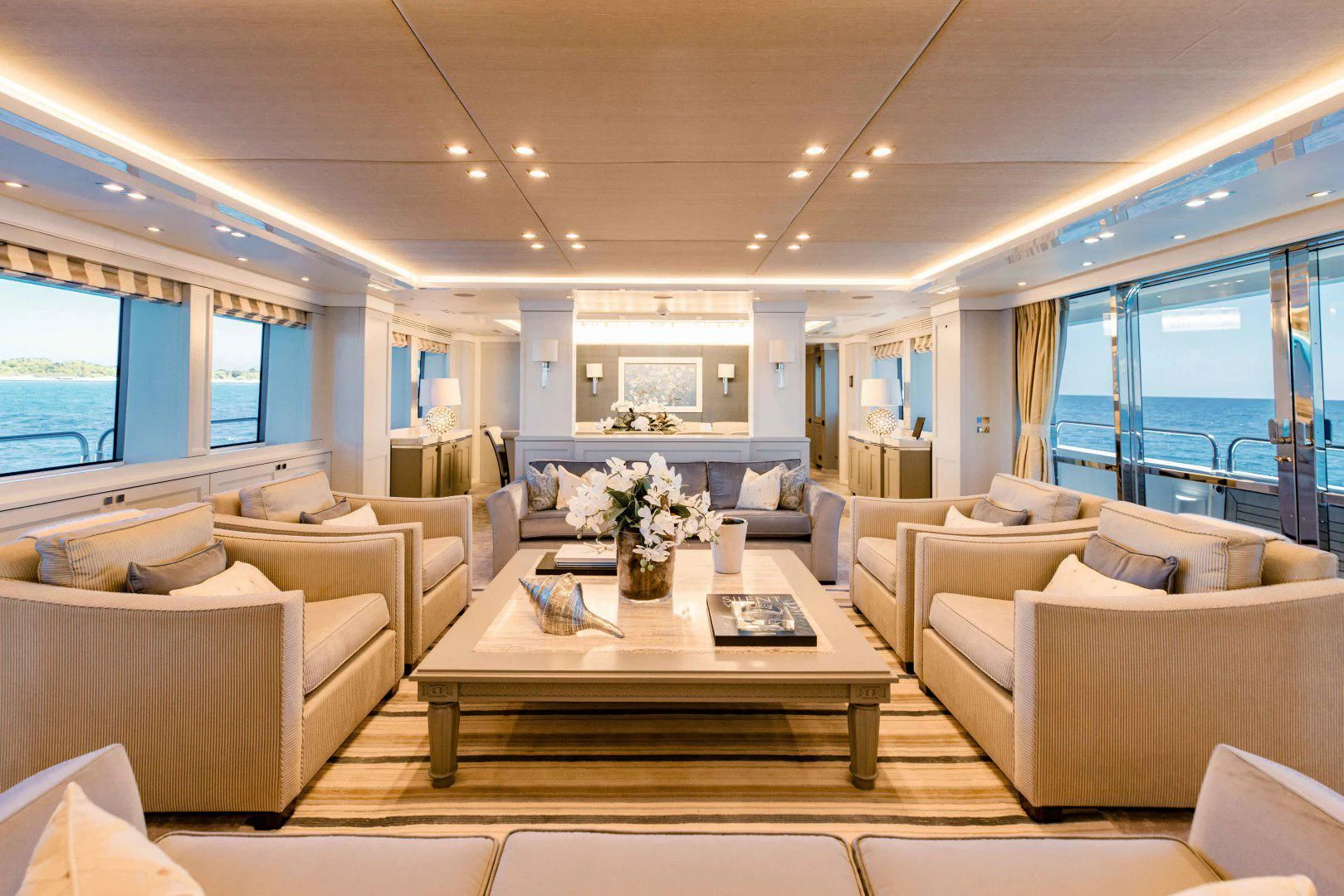 a living room with a table and couches aboard TAYRONA Yacht for Sale
