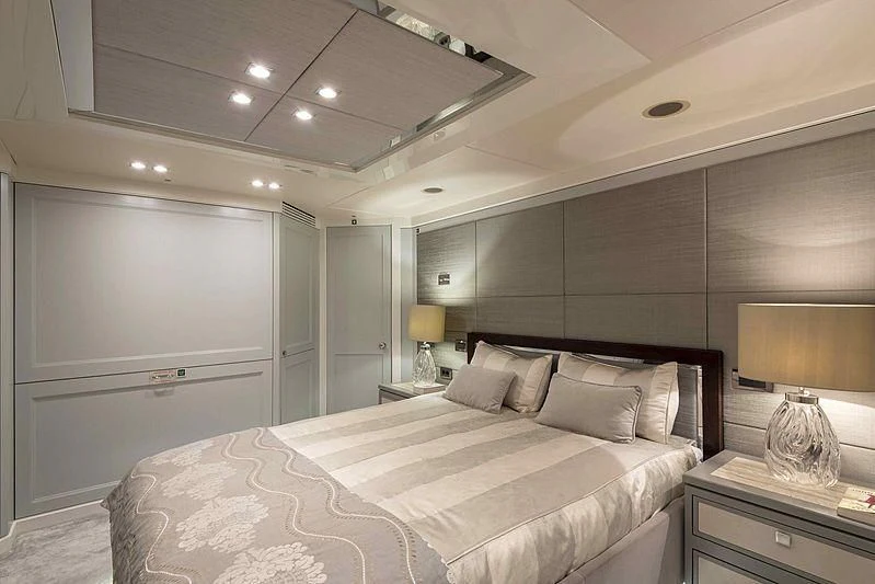 a bedroom with a bed and a lamp aboard TAYRONA Yacht for Sale
