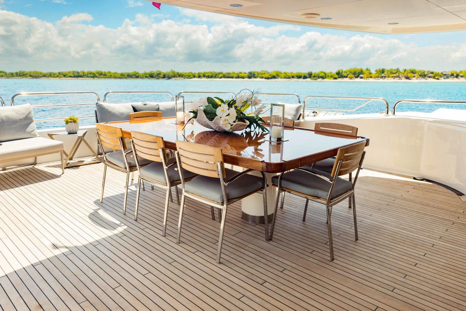 a table set for a meal on a deck overlooking a body of water aboard TAYRONA Yacht for Sale