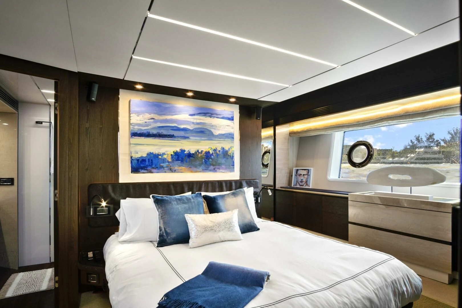 a bed with a painting on the wall aboard GRATITUDE Yacht for Sale