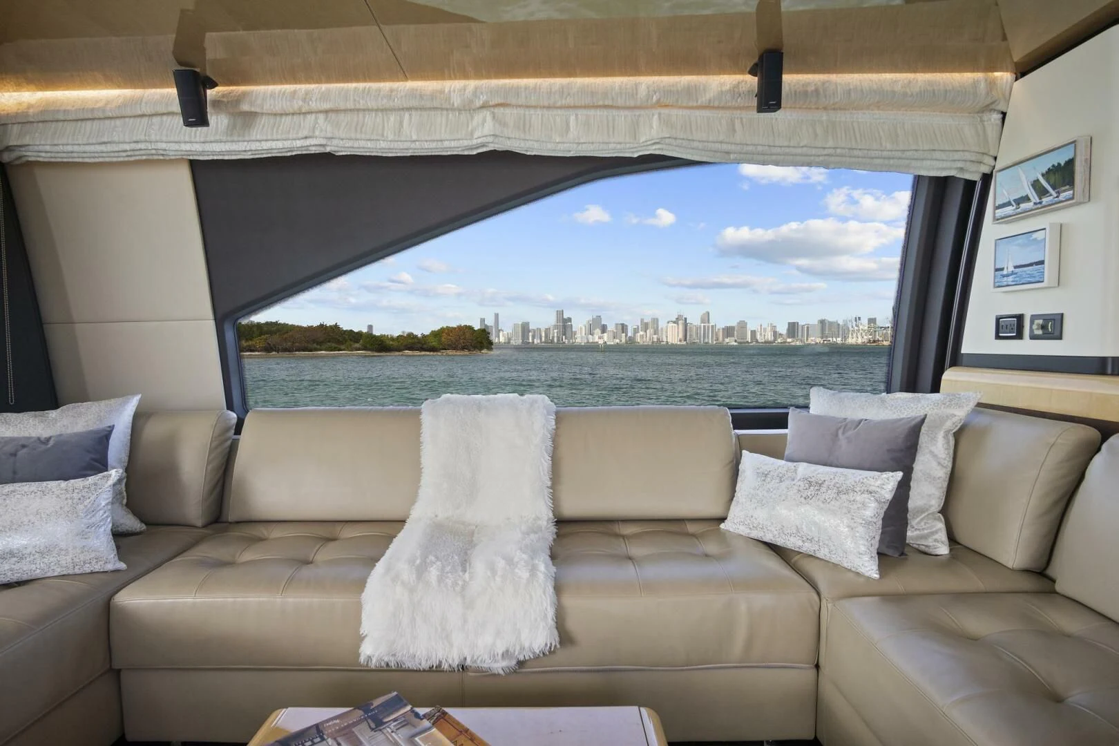 a couch with pillows and a view of a city aboard GRATITUDE Yacht for Sale