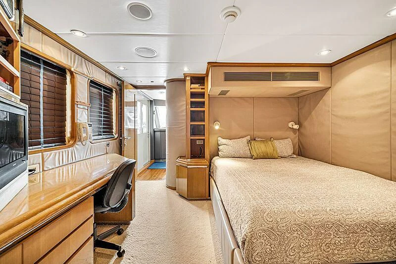 a bedroom with a bed and a desk aboard MAVERICK Yacht for Charter