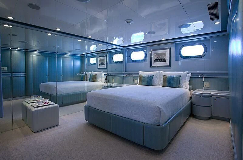 a room with a bed and a blue wall aboard MAVERICK Yacht for Charter